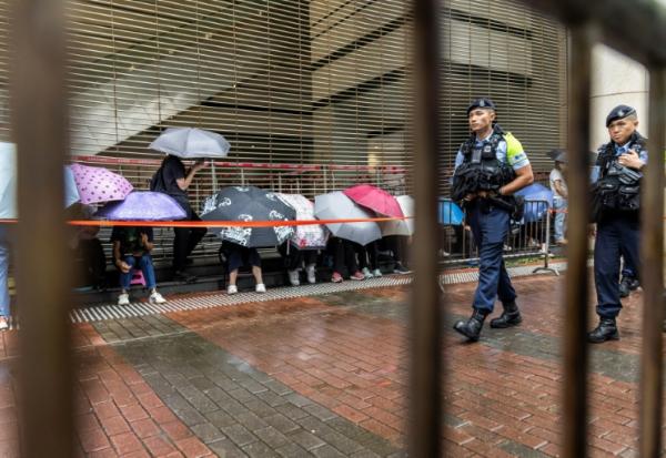 Des policiers devant le tribunal de West Kowloon avant l'arrivée du magnat des médias Jimmy Lai pour son procès à Hong Kong, le 18 août 2025
