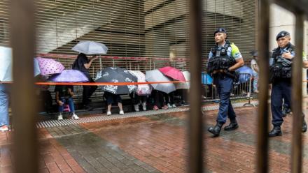 Des policiers devant le tribunal de West Kowloon avant l'arrivée du magnat des médias Jimmy Lai pour son procès à Hong Kong, le 18 août 2025