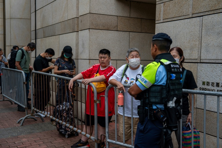 Des personnes attendent devant le tribunal de West Kowloon où se déroule le procès du magnat des médias Jimmy Lai, le 28 août 2025 à Hong Kong