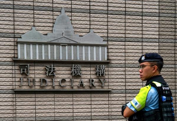 Un policier monte la garde devant le tribunal de West Kowloon où se déroule le procès du magnat des médias emprisonné Jimmy Lai, le 28 août 2025 à Hong Kong