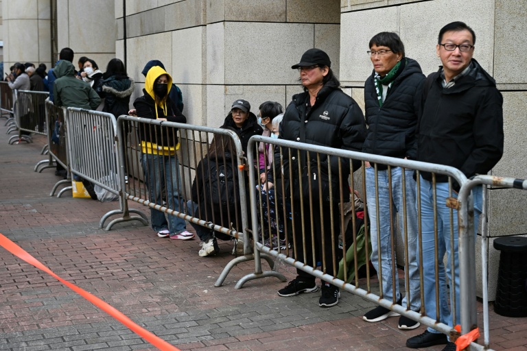 Des personnes attendent devant le tribunal de West Kowloon avant les débats sur la peine à infliger à l'ex-magnat des médias prodémocratie Jimmy Lai, le 12 janvier 2026 à Hong Kong