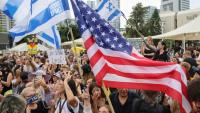Des personnes agitent des drapeaux israéliens et américains sur la place des otages à Tel-Aviv le 9 octobre, après l'annonce d'un accord entre Israël et le Hamas