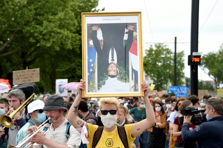 Un manifestant tient un portrait d'Emmanuel Macron lors d'une 