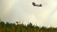 Un hélicoptère bombardier d'eau CH-47D Chinook du Rural Fire Service (RFS) de Nouvelle-Galles du Sud (Australie) et un hélicoptère de la Sécurité civile française survolent la forêt de Luglon lors d'un incendie de forêt, le 14 août 2026 dans les Landes