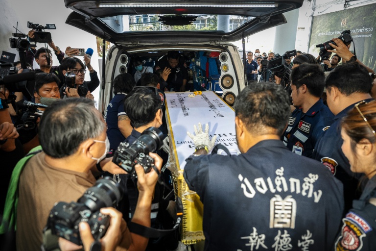 Un cercueil contenant la dépouille d'une victime d'un incendie dans un bar, placé dans un fourgon à l'hôpital général de la police de Bangkok, le 14 juillet 2026 en Thaïlande