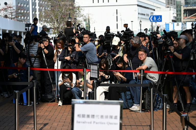Des journalistes attendent, le 19 mars 2026 à Hong Kong,  l'arrivée des participants aux audiences publiques du comité d'enquête sur l'incendie qui a ravagé fin 2025 un complexe résidentiel