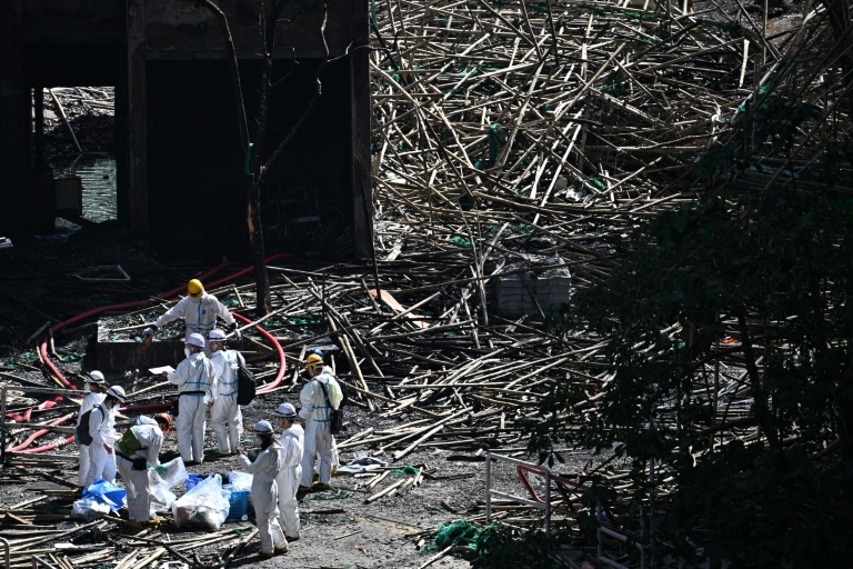Des policiers de l'unité d'identification, équipés de combinaisons blanches, sur les lieux de l'incendie le 29 novembre 2025 at Wang Fuk Court, Hong Kong