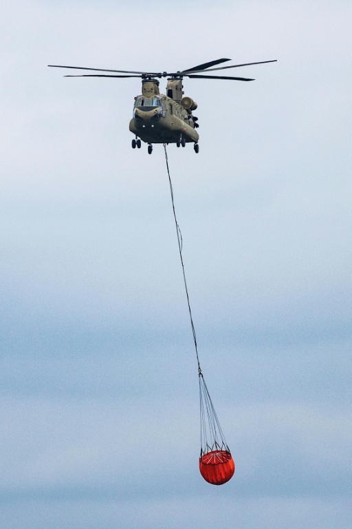 Un hélicoptère Chinook transporte de l'eau pour lutter contre un incendie dans les Hautes Fagnes, un parc naturel dans l'est de la Belgique, mercredi 19 août 2026
