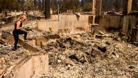 Kimber Renz regarde les ruines de sa maison détruite par les flammes à Spokane, dans l'Etat de Washington, le 4 août 2026