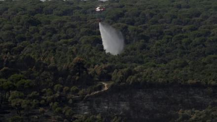 Un hélicoptère de lutte contre les incendies largue de l'eau pour rafraîchir une zone touchée par des feux de forêt à l'ouest de Madrid, le 28 juillet 2026