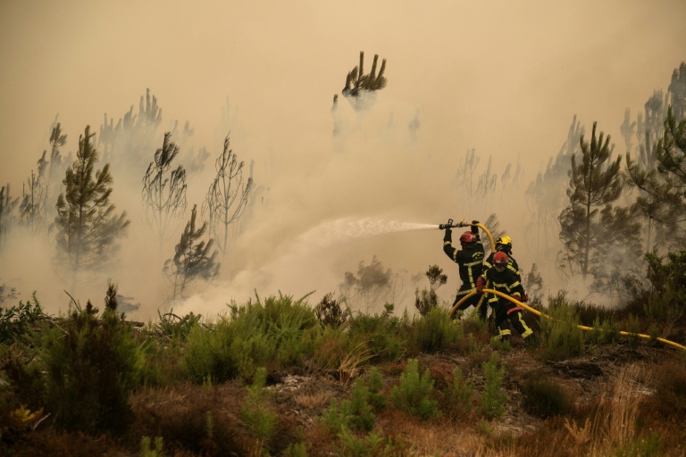 Des pompiers arrosent la lisière d'une forêt lors d'un incendie de forêt près de la ville de Lège-Cap-Ferret, en Gironde, le 25 juillet 2026