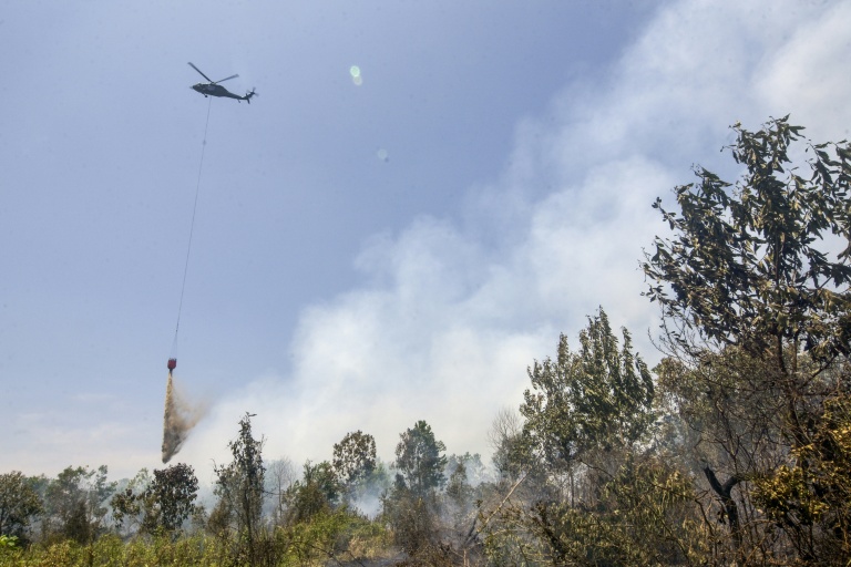 Un hélicoptère largue de l’eau sur des forêts et des terres en feu dans les zones de Tegal Arum et Guntung Damar, à Banjarbaru, dans la province de Kalimantan du Sud, en Indonésie, le 19 septembre 2026