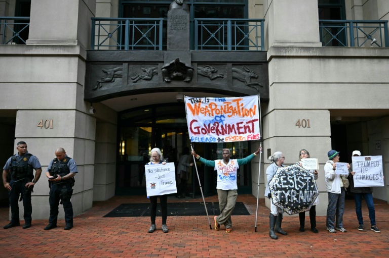 Des manifestants protestent contre l'inculpation de l'ancien directeur du FBI, la police fédérale américaine, James Comey, devant le tribunal fédéral d'Alexandria, aux Etats-Unis, le 8 octobre 2025