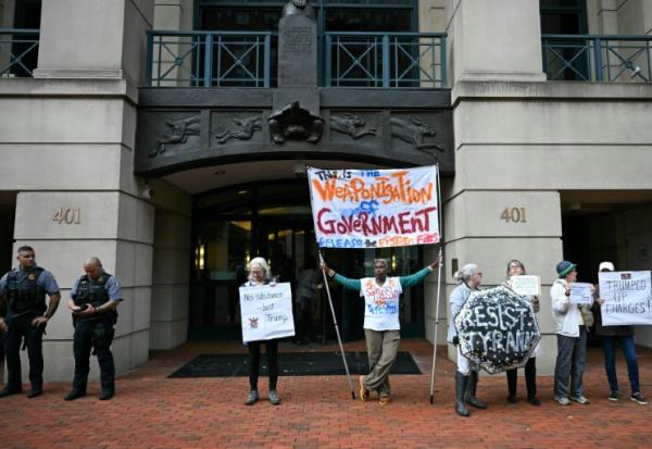 Des manifestants protestent contre l'inculpation de l'ancien directeur du FBI, la police fédérale américaine, James Comey, devant le tribunal fédéral d'Alexandria, aux Etats-Unis, le 8 octobre 2025