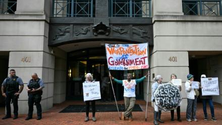 Des manifestants protestent contre l'inculpation de l'ancien directeur du FBI, la police fédérale américaine, James Comey, devant le tribunal fédéral d'Alexandria, aux Etats-Unis, le 8 octobre 2025