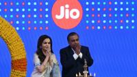 Le milliardaire indien et président de Reliance Industries, Mukesh Ambani (d), et son épouse Nita Ambani, saluent l'assistance lors de l'introduction en bourse de Jio Platforms à la Bourse de Bombay, le 28 octobre 2026 en Inde