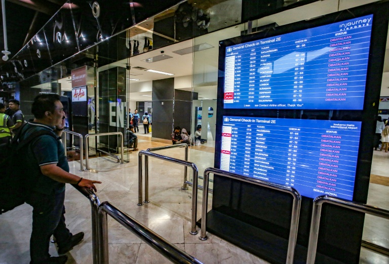 Un voyageur à l'aéroport Soekarno-Hatta de Tangerang après l'éruption du volcan Anak Krakatoa consulte le tableau des départs pour connaître le statut des vols, le 6 septembre 2026 en Indonésie
