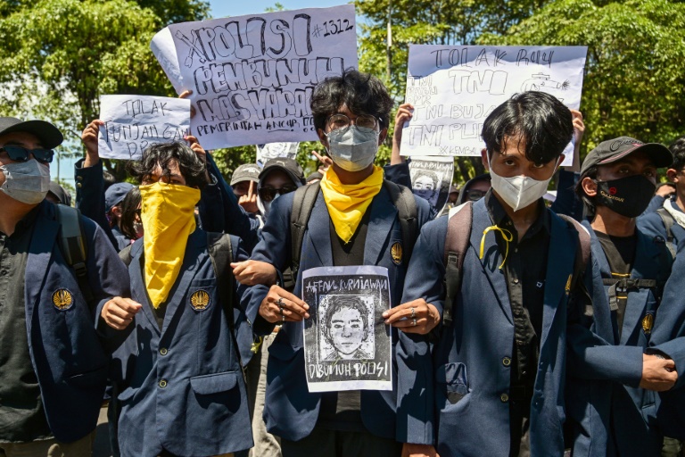 Un manifestant tient le portrait d'Affan Kurniawan, un taxi-moto écrasé par un véhicule de police dont la mort a provoqué des manifestations dans toute l'Indonésie, le 30 août 2025 à Surabaya, sur l'île de Java
