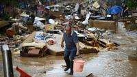 Un habitant récupère de l'eau de pluie dans une zone inondée après la rupture d'un réservoir près de Gantang, dans la région du Guangxi, le 9 juillet 2026 dans le sud-ouest de la Chine