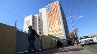 Un Iranien passe devant une immense fresque anti-américaine peinte sur un bâtiment dans la capitale iranienne, Téhéran, le 31 janvier 2026