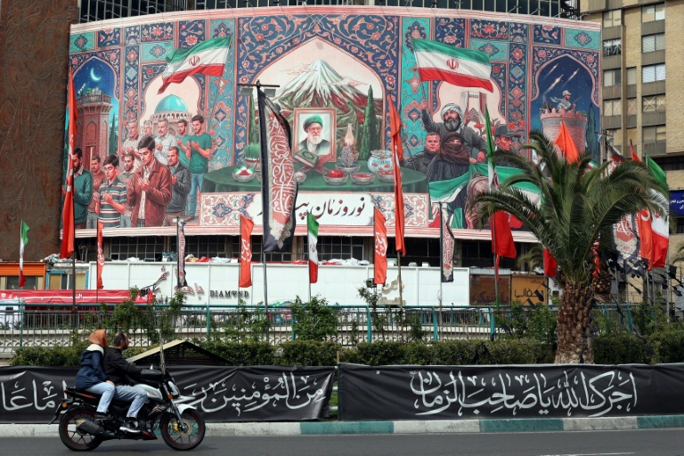Une peinture murale avec un portrait de l'ayatollah Ali Khamenei, le guide suprême iranien tué le 28 février, le 22 mars 2026 sur la place Valiasr de Téhéran