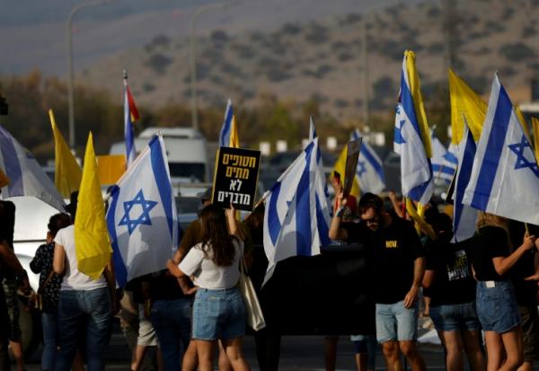 Des manifestants israéliens réclament une trêve à Gaza et la libération des otages, près du du kibboutz Amiad dans le nord d'Israël le 26 août 2025 avant une réunion du gouvernement israélien en soirée.
