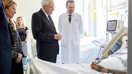 Photo publiée par les services de la présidence italienne montrant le président Sergio Mattarella (C) et la présidente du Conseil Giorgia Meloni (G) au chevet d'une des victimes renversées par un conducteur ayant des antécédents psychiatriques, le 17 mai 2026 à Modène
