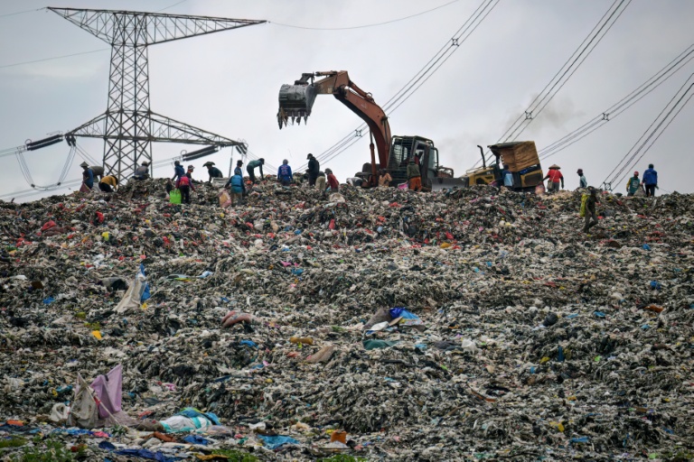 Des engins de chantier nivellent un énorme tas de déchets à la décharge de Cipayung à Depok, le 15 janvier 2026 en Indonésie