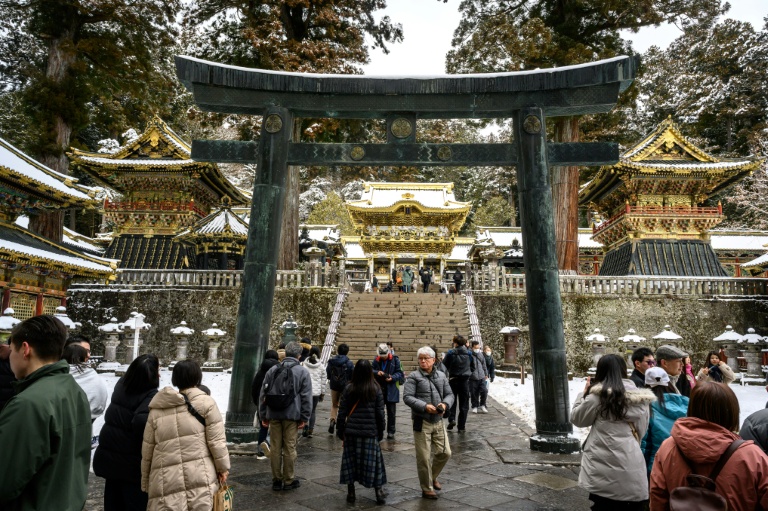 Des touristes visitent le sanctuaire Toshogu enneigé, un site touristique inscrit au patrimoine mondial de l'Unesco, le 10 février 2025 à Nikko, au Japon