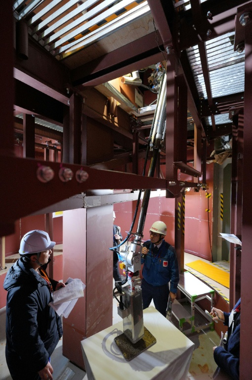 Un bras robotique effectue une démonstration d'enlèvement de débris de combustible nucléaire fondu lors d'une simulation à la centrale nucléaire de Fukushima Daiichi, exploitée par Tokyo Electric Power Company, le 25 février 2026 à Naraha, dans la préfecture de Fukushima, au Japon