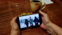 Une personne regarde sur un smartphone un fil d'actualité diffusant des images du FSB russe montrant l'opération d'interpellation d'un journaliste japonais accusé d'espionnage, à Moscou, le 13 octobre 2026