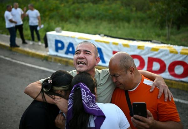 Le prisonnier vénézuélien Richard Puentes (C) enlace des membres de sa famille après sa libération de la prison El Rodeo 1, à Guatire, dans l’État de Miranda, au Venezuela, le 23 février 2026