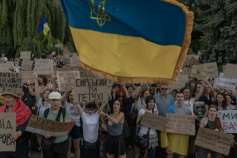 Des manifestants brandissent un drapeau ukrainien lors d’une manifestation contre la décision du président ukrainien de limoger le ministre de la Défense Mykhaïlo Fedorov, à Kiev le 18 juillet 2026