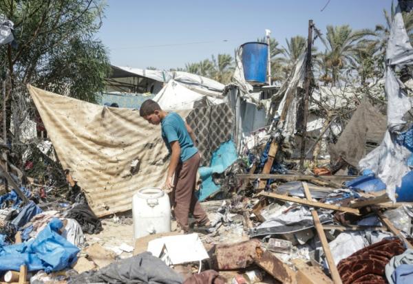 Un jeune Palestinien déplacé examine les dégâts sur le site d'une frappe israélienne présumée contre une tente à Khan Younès, dans le sud de la bande de Gaza, le 16 août 2026