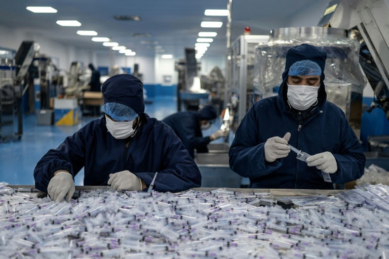 Des ouvriers assemblent et emballent des seringues jetables à l'usine pharmaceutique Milli Shifa (MSP), en périphérie de Kaboul, le 3 février 2026 en Afghanistan