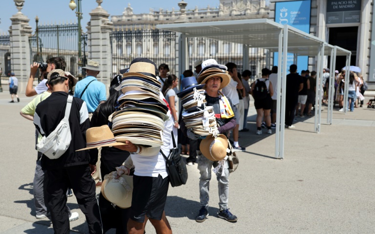 Des vendeurs de chapeaux devant le Palais royal à Madrid en pleine canicule, le 2 juillet 2025