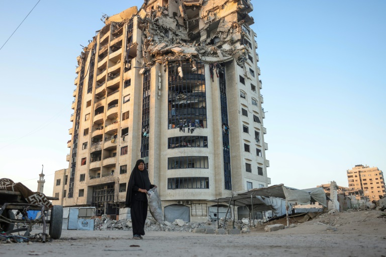 Une Palestinienne passe devant un bâtiment gravement endommagé dans la ville de Gaza, le 29 août 2025