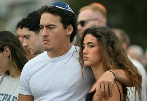 Des personnes assistent à la cérémonie en hommage aux victimes de la tuerie antisémite de Bondi Beach, à Sydney, le 21 décembre 2025