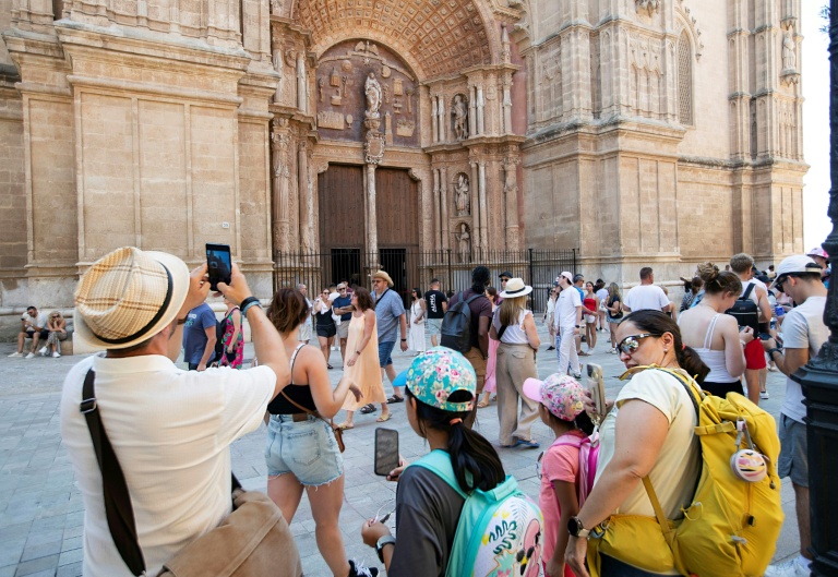 Des touristes visitent la cathédrale de Palma de Majorque, le 1er août 2025 aux Baléares, en Espagne