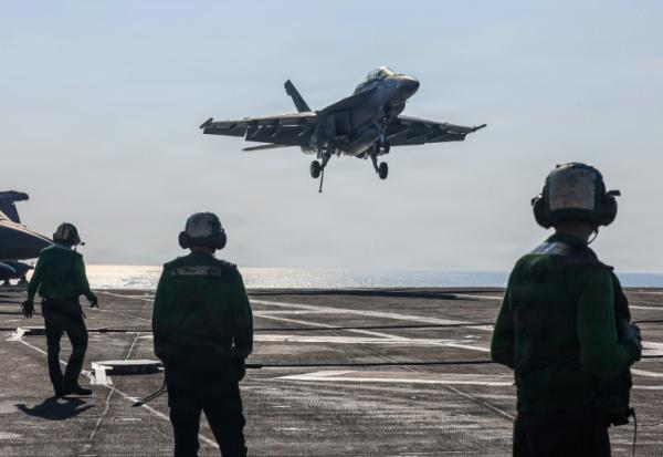 Cette photo fournie par l'US Navy montre un chasseur Super Hornet F/A-18F atterrisant sur le pont du porte-avions  USS Abraham Lincoln en mer d'Oman, le 30 janvier 2026