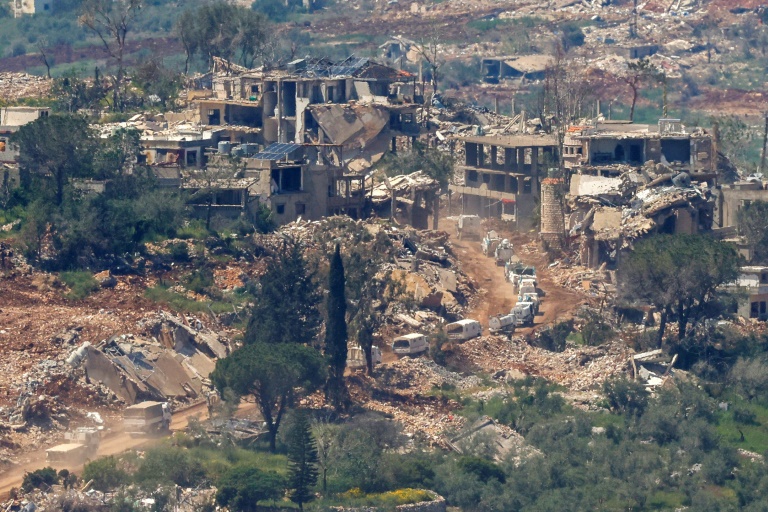 Photo prise depuis le nord d'Israël montrant un convoi des Nations unies (ONU) circulant à proximité de maisons détruites dans le sud du Liban, près de la frontière avec Israël, le 29 avril 2026