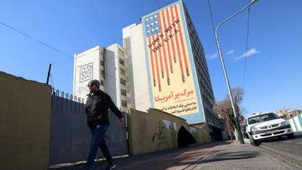 Un Iranien passe devant une immense fresque anti-américaine peinte sur un bâtiment dans la capitale iranienne, Téhéran, le 31 janvier 2026