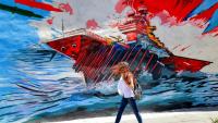 Une femme passe devant une peinture murale anti-américaine et anti-israélienne, le 26 mai 2026 à Téhéran
