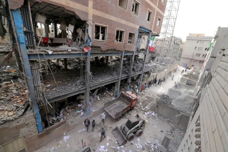 Des ouvriers iraniens déblaient les gravats d'habitations détruites, le 15 mars 2026 à Téhéran