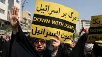 Une Iranienne brandit une pancarte "Down with Israël" ("A bas Israël" en français) lors d'une manifestation anti-israélienne après la prière du vendredi midi à Téhéran, le 19 avril 2024