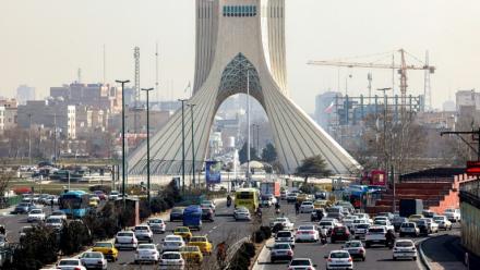 Des véhicules circulent sur une autoroute près de la célèbre Tour Azadi à Téhéran le 23 février 2026