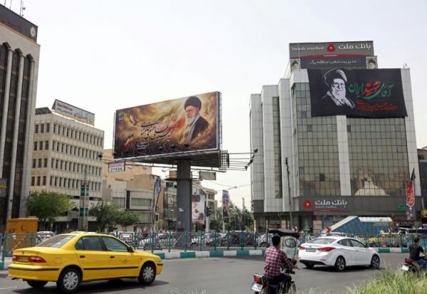 Des automobilistes passent devant d'immenses panneaux publicitaires arborant des photos de l'ayatollah Ali Khamenei, le défunt guide suprême de l'Iran, le 2 juillet 2026 à Téhéran, à la veille de ses funérailles
