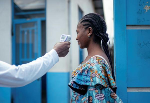 Un membre du personnel de l'hôpital CBCA Virunga prend la température d'une visiteuse à l'aide d'un thermomètre infrarouge sans contact avant de l'autoriser à entrer dans l'hôpital de Goma, en République démocratique du Congo, le 17 mai 2026. 