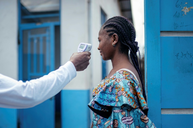 Un membre du personnel de l'hôpital CBCA Virunga prend la température d'une visiteuse à l'aide d'un thermomètre infrarouge sans contact avant de l'autoriser à entrer dans l'hôpital de Goma, en République démocratique du Congo, le 17 mai 2026. 