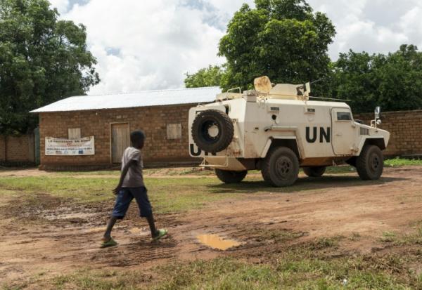 Un enfant passe devant un blindé de la Minusca à Maloum, en Centrafrique, le 24 juillet 2025